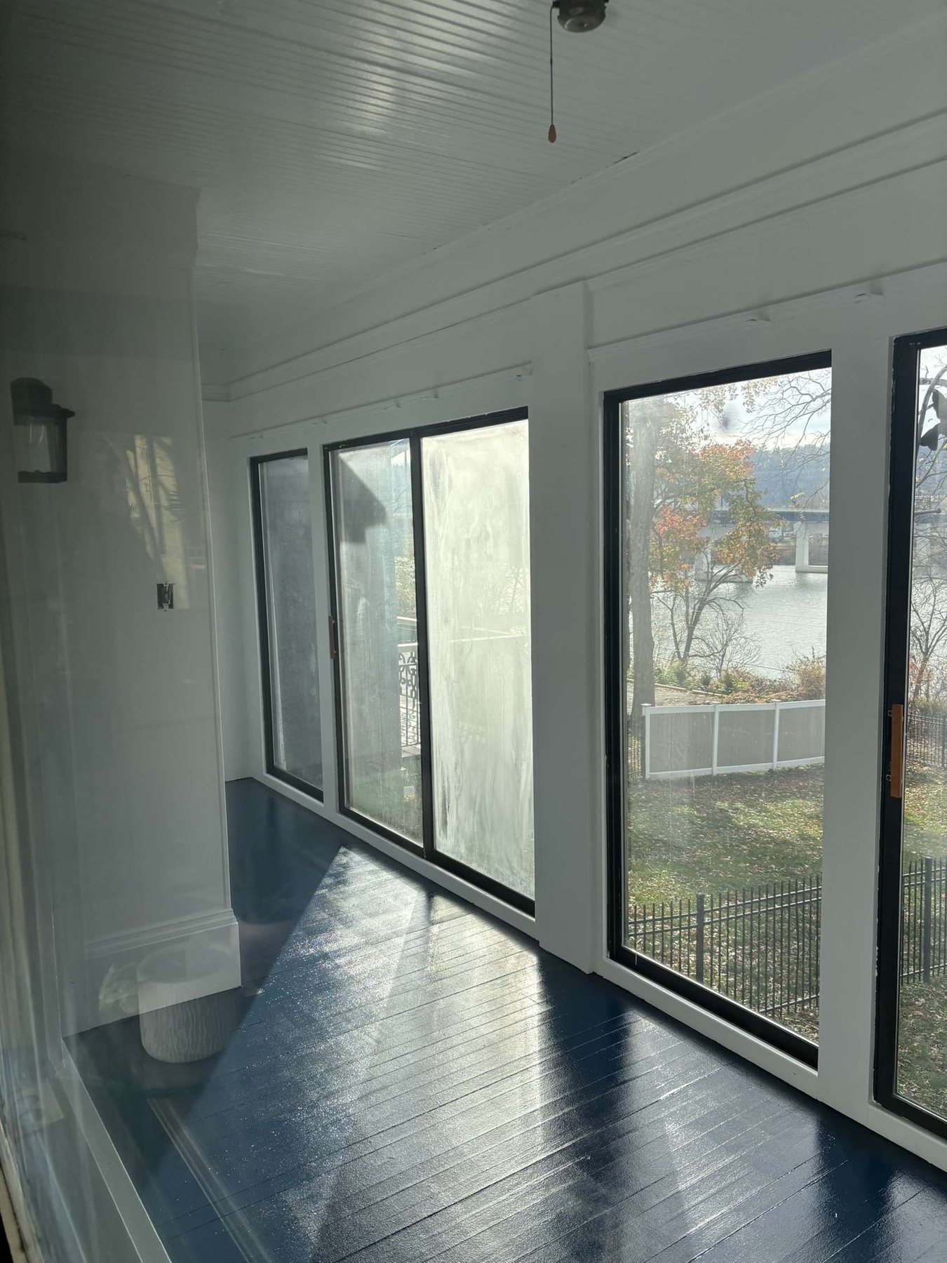 Bright painted sunroom with dark floor